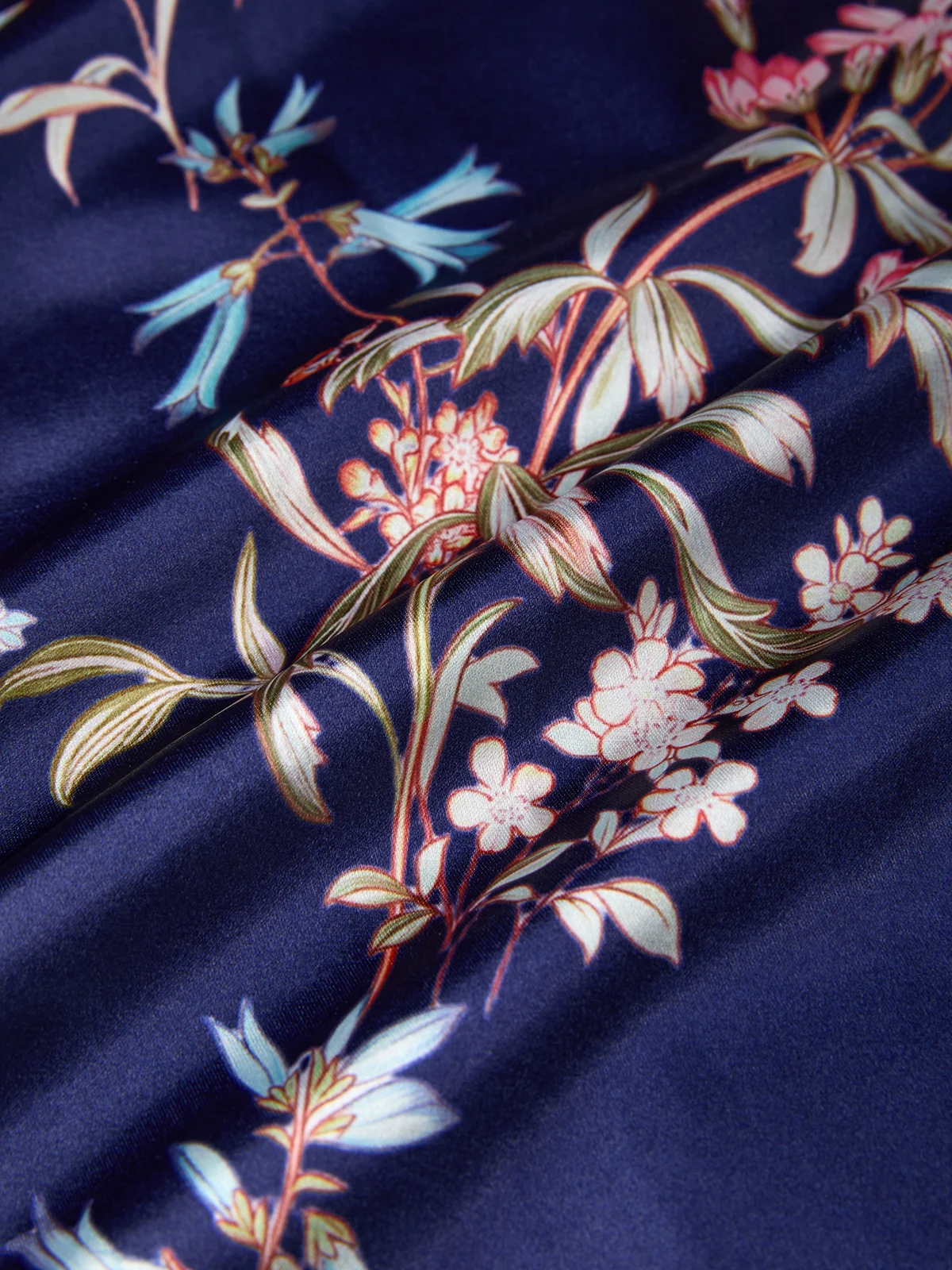 Close-up of navy satin-look fabric with botanical floral print
